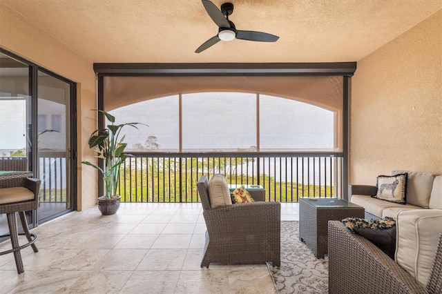 sunroom / solarium featuring plenty of natural light and ceiling fan