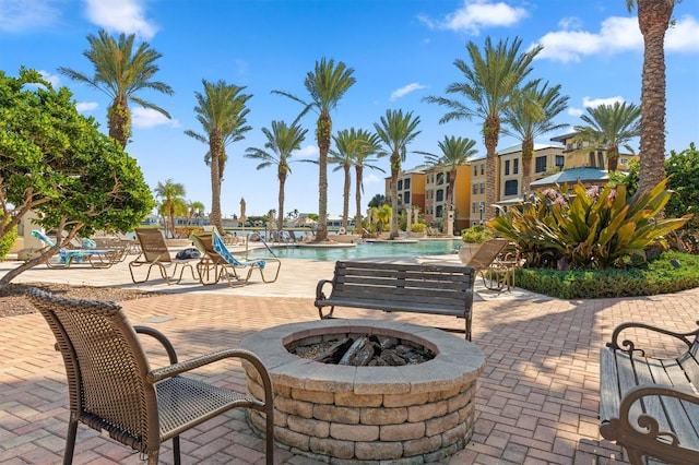 view of patio featuring an outdoor fire pit and a community pool