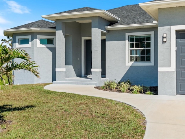 view of exterior entry featuring a lawn