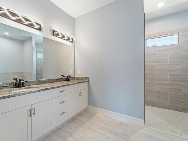 bathroom featuring tiled shower, vanity, and hardwood / wood-style flooring