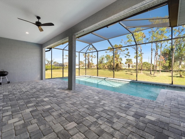 view of pool with a lanai, a patio area, ceiling fan, and a lawn