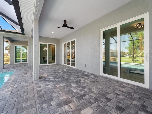 view of patio with glass enclosure and ceiling fan