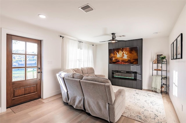 living room with ceiling fan and light wood-type flooring