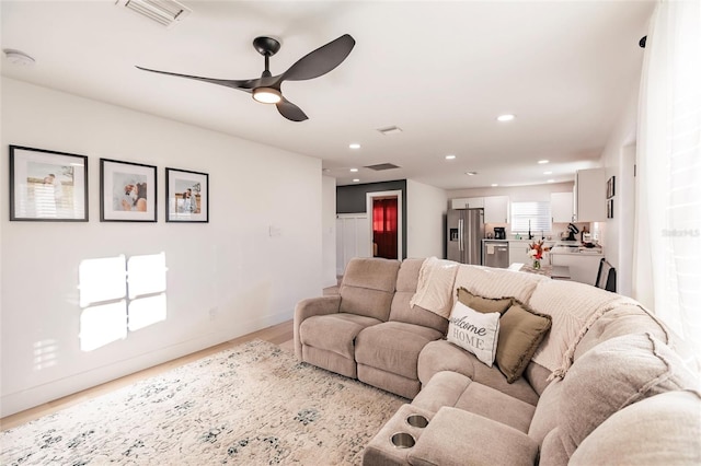 living room featuring light wood-type flooring and ceiling fan