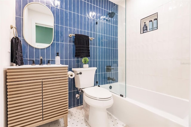 full bathroom with vanity, toilet, tile walls, and shower / washtub combination