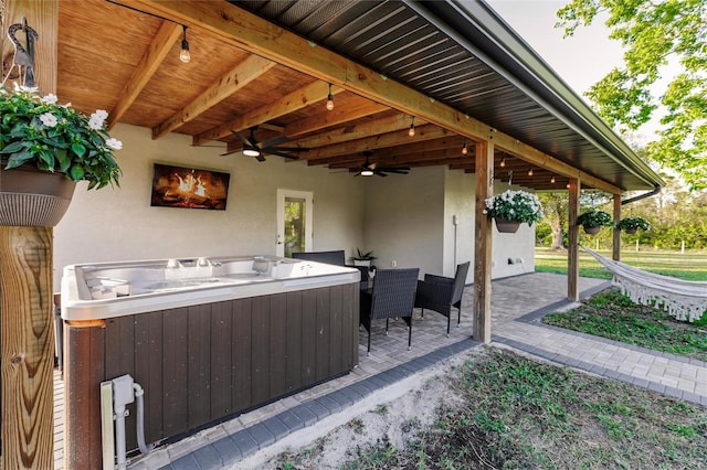 view of patio / terrace featuring ceiling fan and a hot tub