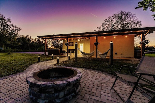 1010 Robinhood Dr, Punta Gorda, FL 33982 - patio terrace at dusk featuring a patio area, a lawn, and a fire pit