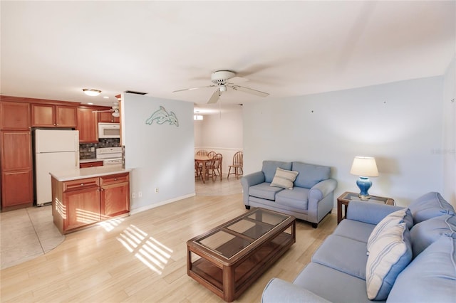 living room featuring ceiling fan and light hardwood / wood-style flooring