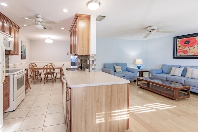 kitchen featuring white appliances, light hardwood / wood-style floors, ceiling fan, and sink