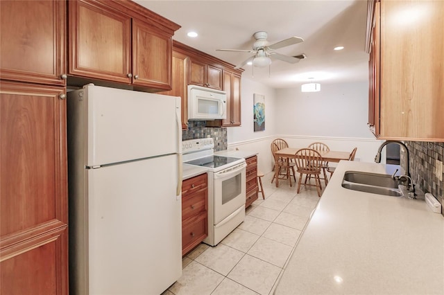 kitchen featuring tasteful backsplash, ceiling fan, sink, and white appliances