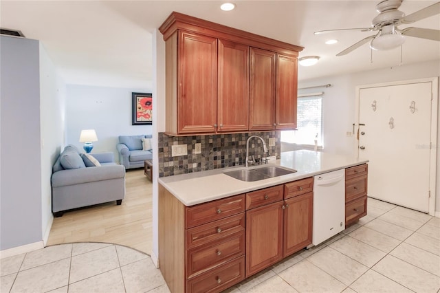 kitchen featuring decorative backsplash, dishwasher, light tile patterned floors, and sink