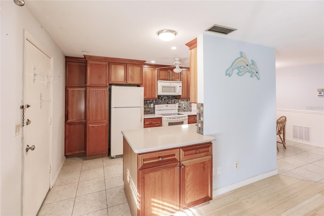 kitchen with decorative backsplash, ceiling fan, white appliances, and light tile patterned floors