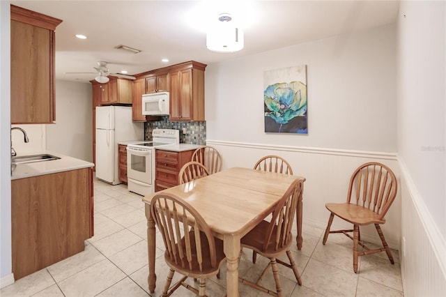 tiled dining room featuring ceiling fan and sink