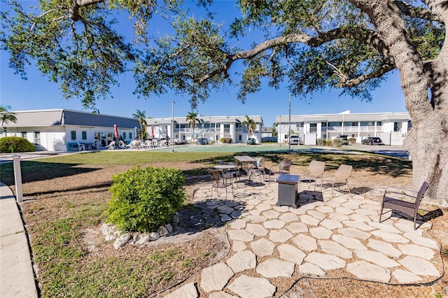 view of property's community featuring a lawn and a patio