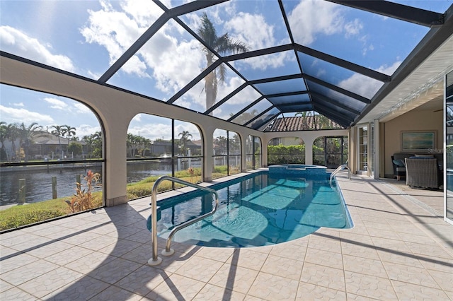 view of swimming pool featuring glass enclosure, a patio area, a water view, and an in ground hot tub