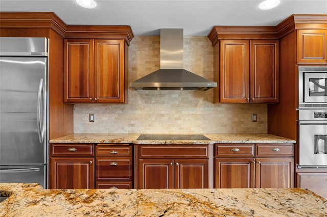 kitchen with light stone countertops, backsplash, wall chimney exhaust hood, a textured ceiling, and stainless steel appliances