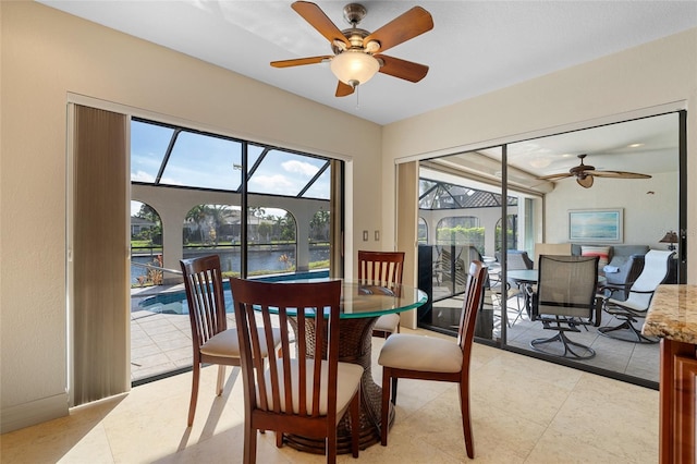 dining space featuring a water view and ceiling fan