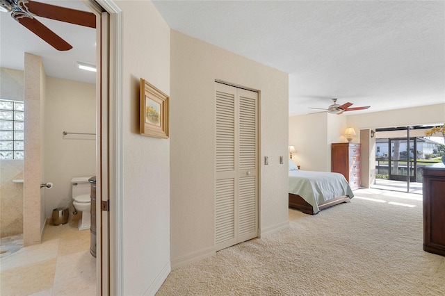 carpeted bedroom with ceiling fan, a closet, access to exterior, and multiple windows