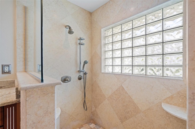 bathroom featuring a tile shower and vanity