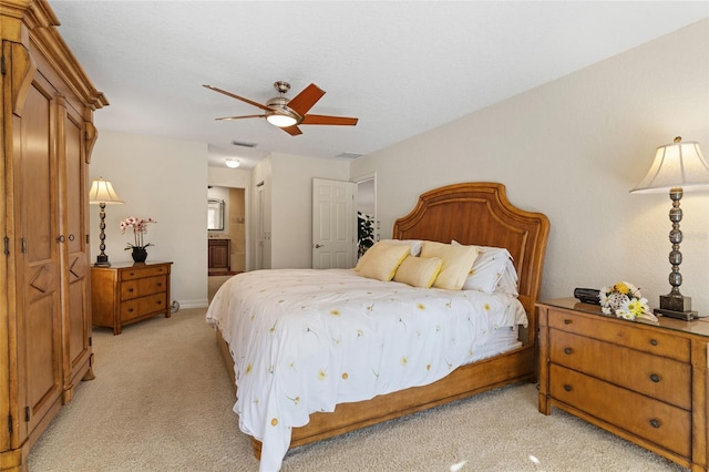 carpeted bedroom featuring connected bathroom and ceiling fan