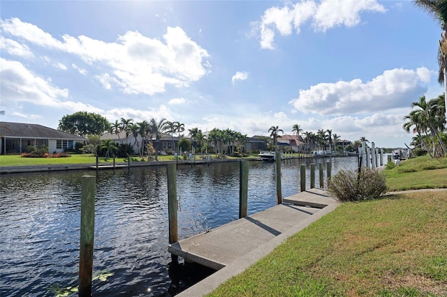 dock area with a lawn and a water view