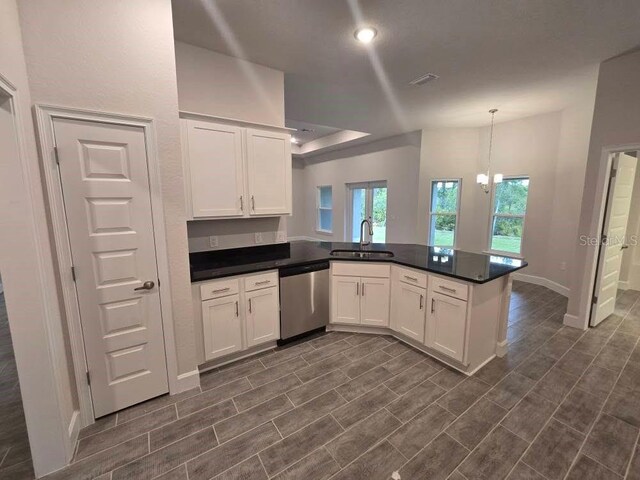 kitchen with a sink, a peninsula, white cabinetry, and stainless steel dishwasher