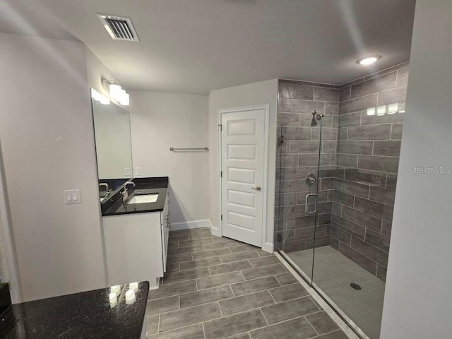 bathroom featuring baseboards, visible vents, a shower stall, and vanity