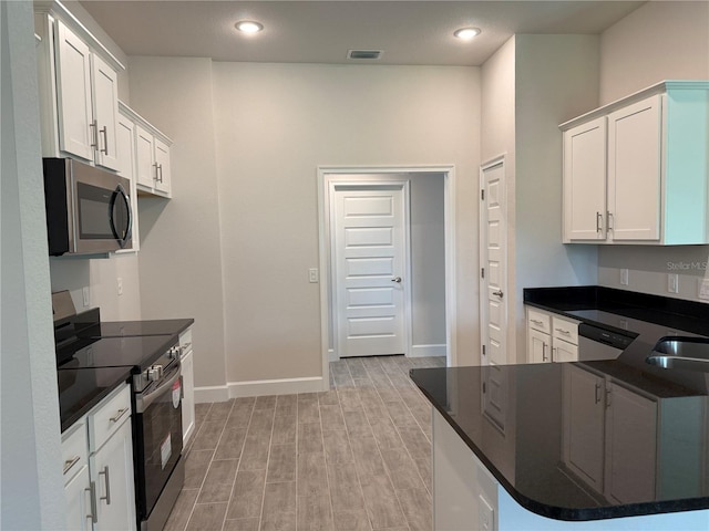 14146 Baracoa Ln, Port Charlotte, FL 33981 - kitchen with appliances with stainless steel finishes, dark countertops, light wood-style flooring, baseboards, and recessed lighting