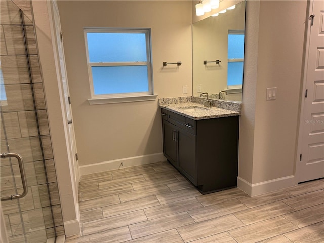 bathroom with a shower with door and vanity