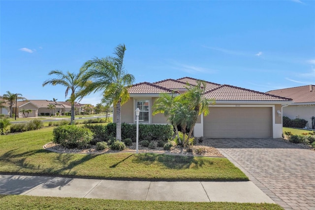 mediterranean / spanish house with a garage and a front lawn