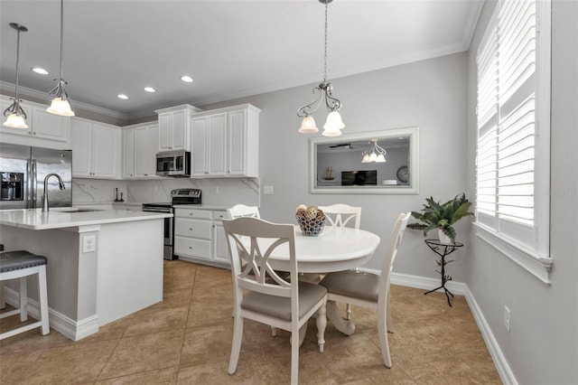 kitchen with an inviting chandelier, stainless steel appliances, white cabinetry, and a wealth of natural light