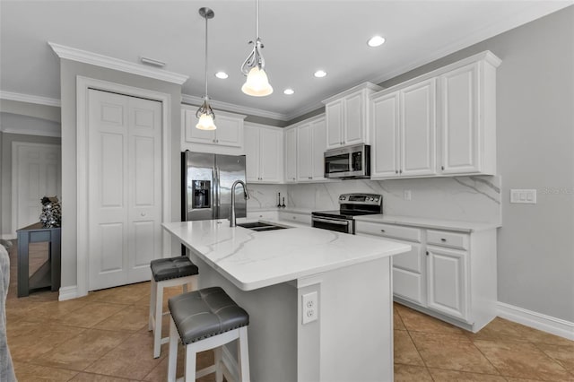 kitchen featuring light stone counters, stainless steel appliances, a kitchen island with sink, sink, and white cabinets