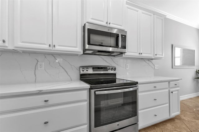 kitchen with white cabinets, appliances with stainless steel finishes, backsplash, and light tile patterned flooring