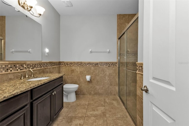 bathroom featuring vanity, tile walls, tile patterned flooring, toilet, and a shower with shower door