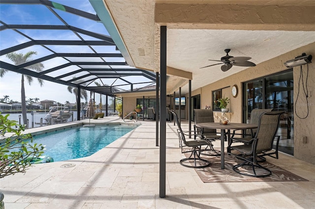 view of swimming pool featuring glass enclosure, ceiling fan, a water view, and a patio area