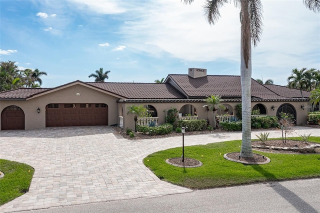 mediterranean / spanish house with a front yard and a garage