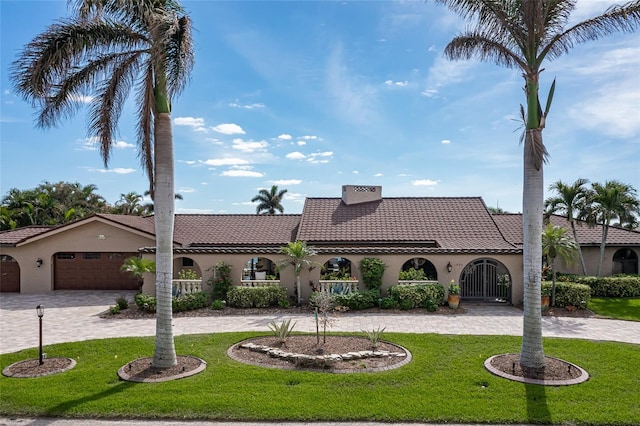 mediterranean / spanish-style home featuring a garage and a front lawn