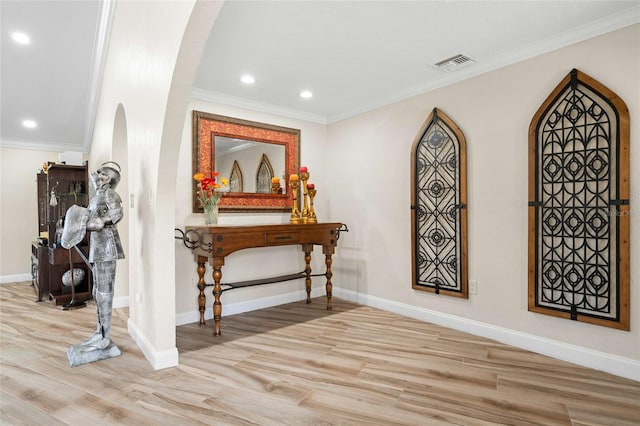 entrance foyer with light hardwood / wood-style floors and crown molding