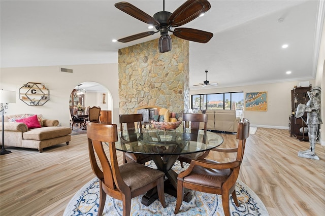 dining space with ceiling fan, vaulted ceiling, crown molding, and light hardwood / wood-style flooring