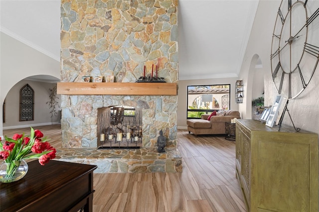 living room featuring a fireplace, light wood-type flooring, and crown molding