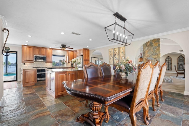 dining room featuring ceiling fan with notable chandelier and ornamental molding