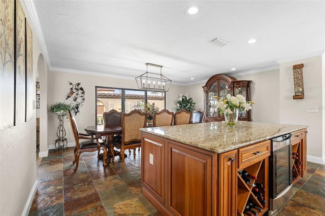 kitchen with a center island, hanging light fixtures, beverage cooler, a notable chandelier, and ornamental molding