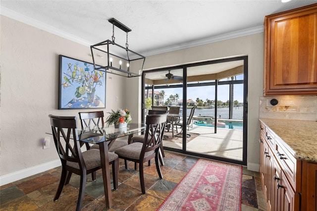 dining space featuring a water view, ceiling fan, and ornamental molding