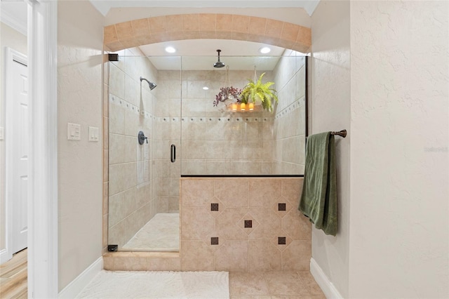 bathroom featuring tile patterned floors, an enclosed shower, and crown molding