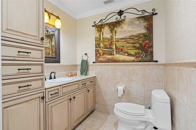 bathroom featuring tile patterned floors, vanity, crown molding, tile walls, and toilet