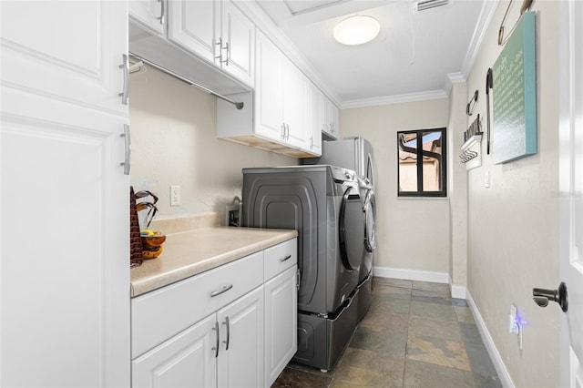 washroom featuring cabinets, crown molding, and washing machine and clothes dryer