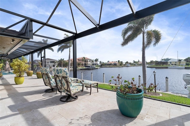 view of patio with a lanai, a water view, and a dock