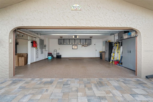 garage featuring stainless steel refrigerator and electric panel