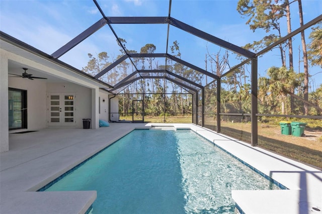 view of pool with glass enclosure, ceiling fan, and a patio