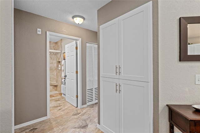 hallway with a textured ceiling